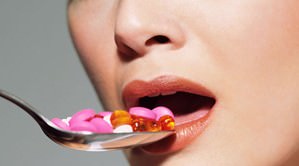 woman swallowing pills